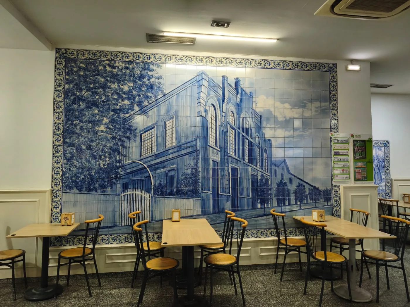 Grande painel de azulejos azuis no interior do Café das Beiras