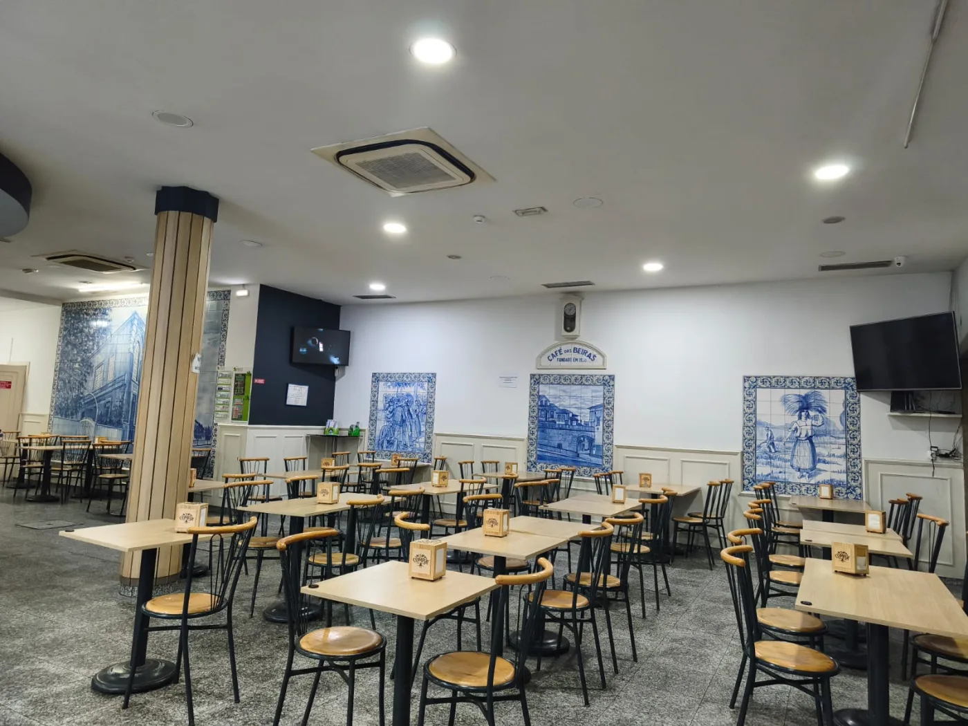 Sala do Café das Beiras com mesas e painéis de azulejos